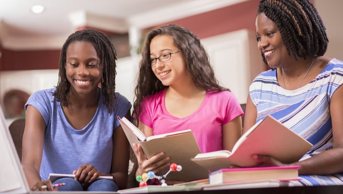 Three diverse girls reading at school